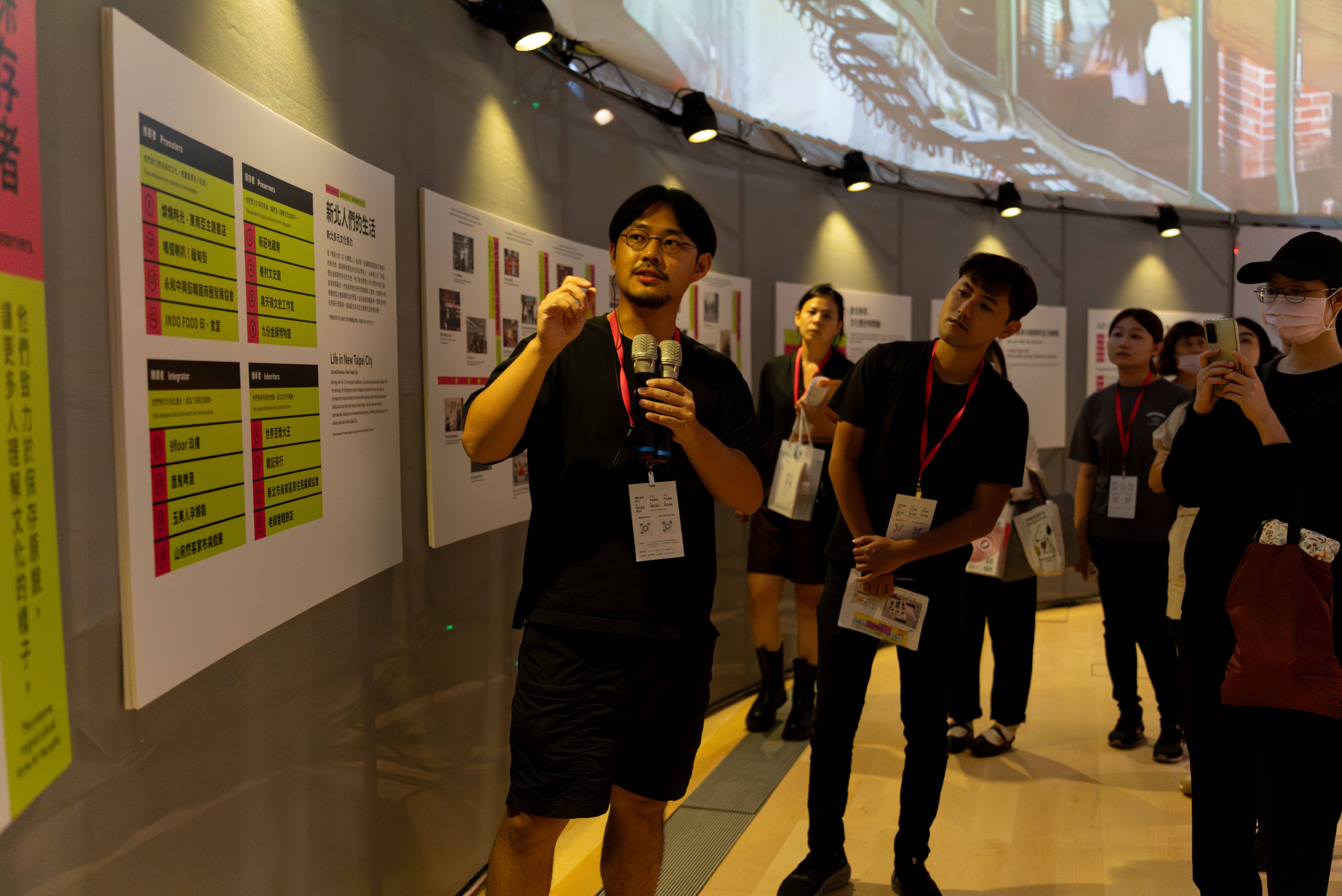 2023台灣設計展中，由工二建築和星濱山共創工作室策劃的「共生〇」《異他方》展區，以300年的時間為軸線，透過16位新北帶路人的故事，詮釋「新北人」的生活樣貌。